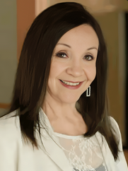 Smiling woman in white blazer and lace top